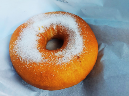 お店で揚げたシュガードーナツにお砂糖をかけた様子